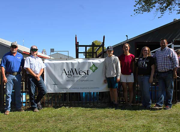 Goup with Jim Logan around AgWest Banner