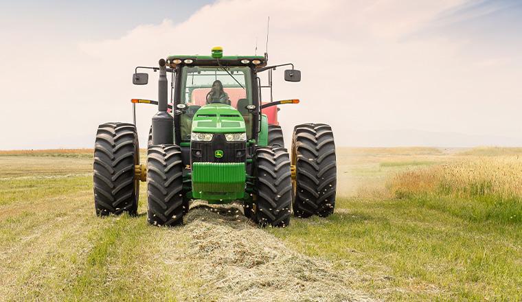 woman riding on a green tractor