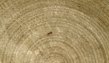 A tractor drives through a field in drought
