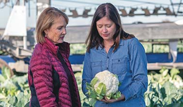 Mother and daughter hold produce